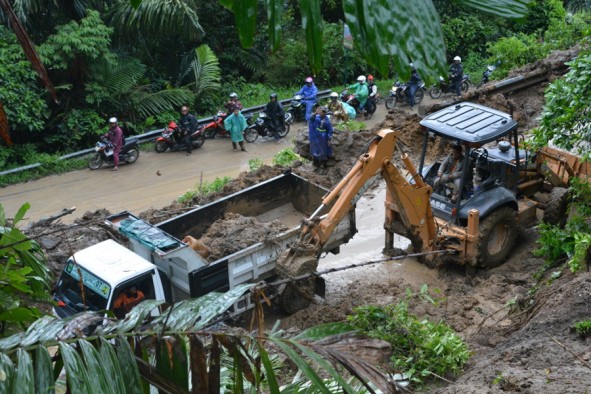 Petugas sedang membersihkan material longsoran di Kelok 44