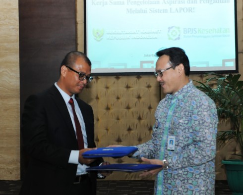 Seskab Andi Wijayanto dan Dirut BPJS Kesehatan Fahmi Idris bertukar dokumen seusai penandatangan kerjasama, di kantor Kemensetneg, Jakarta, Jumat (2/1) sore)