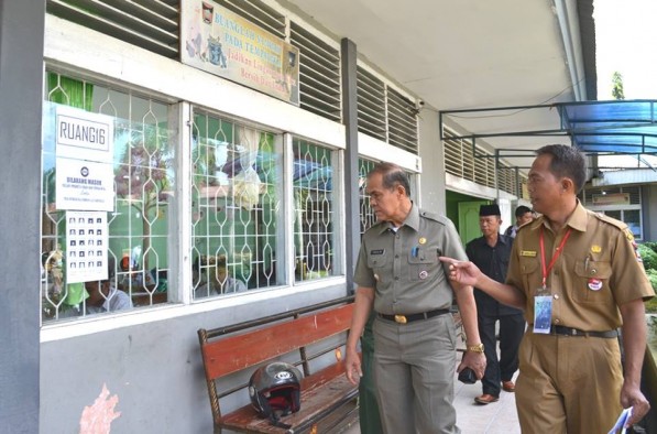 Emzalmi didampingi Kepala Sekolah SMAN 4, Abinul Hakim (kanan) memantau pelaksanaan UN di sekolah tersebut, Senin (13/4)