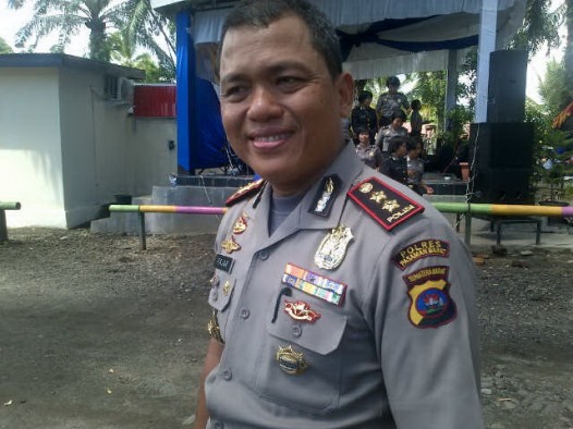 Kapolres Pasbar AKBP Sofyan Hidayat didampingi Kasat Lantas AKP Rio Sigal Hasibuan, memasangkan helm kepada pengendara