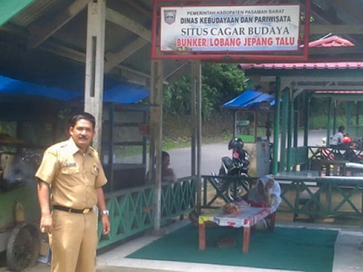 Abdi Surya berdiri di hadapan rumah lepau objek wisata Lubang Jepang Talu Pasaman Barat 