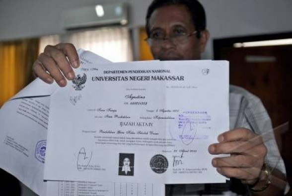 Seorang petugas akademik Universitas Negeri Makassar (UNM) memperlihatkan salah satu ijazah palsu. (Foto Antara)