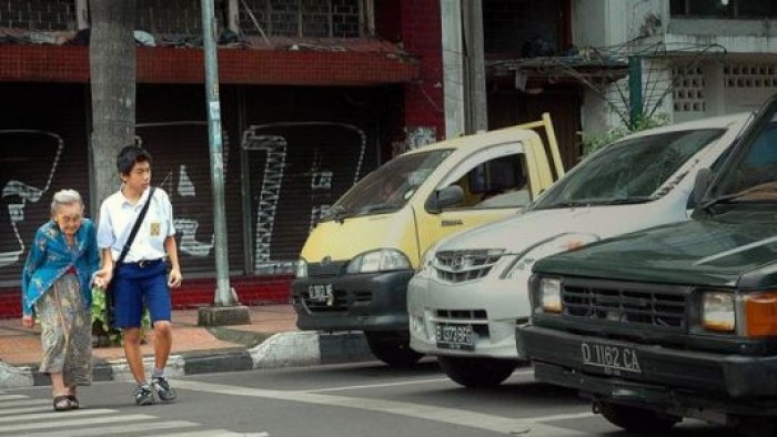 Remaja sedang membantu orang tua yang menyeberang jalan