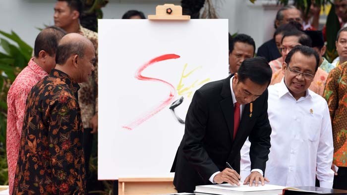 Presiden Jokowi menandatangani buku karya kurator Mikke Susanto dan Rizki A. Zaelani, pada Pembukaan Pameran Lukisan GORESAN JUANG KEMERDEKAAN, Senin (1/8), di Galeri Nasional, Jakarta. (Foto: Humas/Jay)
