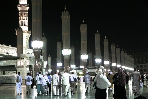 Jamaah melintas di halaman luar Masjid Nabawi setelah salat