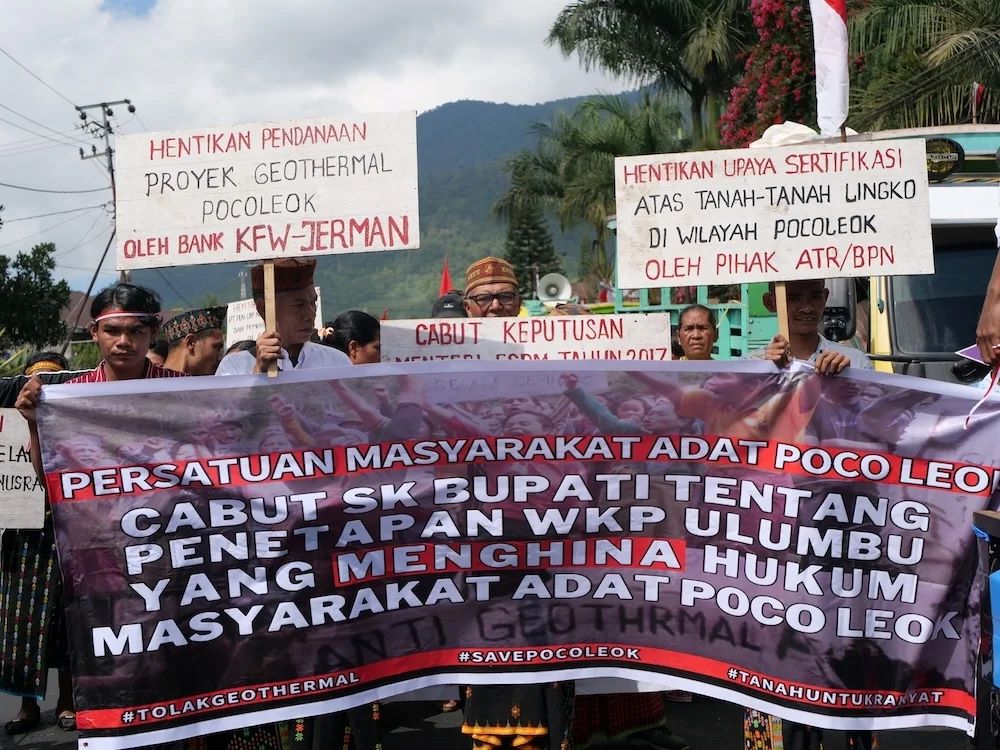 Warga membawa baliho bertuliskan tuntutan-tuntutan aksi, di antaranya menuntut Bank KfW untuk menghentikan pendanaan proyek geothermal dan mencabut SK Bupati Manggarai terkait penetapan lokasi proyek. (Dokumentasi Floresa)