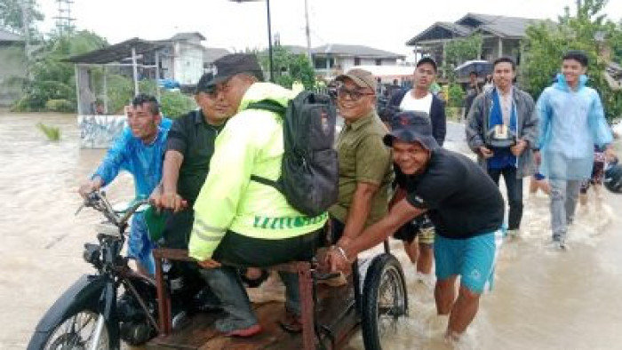 Bupati Yulianto baju hijau naiki becak tinjau banjir di Nagari Aia Gadang Kec Pasaman. 
