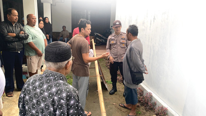 Polisi melakukan olah TKP tempat ditemukannya seorang pensiunan guru yang tewas di halaman rumhanya di kawasan VII Koto Talago, Kecamatan Guguak, Kabupaten Lima Puluh Kota, Jumat (19/12/2025) foto posmetropadang