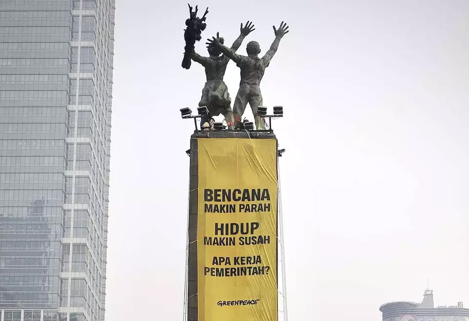 Aktivis Greenpeace Indonesia membentangkan spanduk bertuliskan “Tangani Krisis Iklim, Turunkan Biaya Hidup” di kawasan Bundaran Hotel Indonesia, Jakarta, Selasa (20/10/2026), untuk mendesak pemerintah lebih serius menangani krisis iklim. (Greenpeace/Ist)
